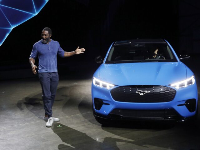 Bill Ford, chairman of Ford Motor Co., left, listens to actor Idris Elba speaking as the Ford Motor Co. Mustang Mach-E GT electric sports utility vehicle (SUV) is unveiled during a reveal event in Hawthorne, California, U.S., on Sunday, Nov. 17, 2019. Ford is reinventing one of its marquee models …