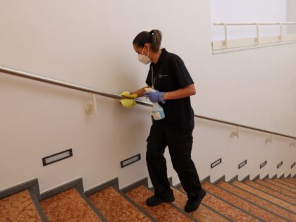 A cleaner wipes a handrail on day three of the World Economic Forum (WEF) in Davos, Switze