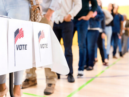 Low angle view of people lined up to vote - stock photo