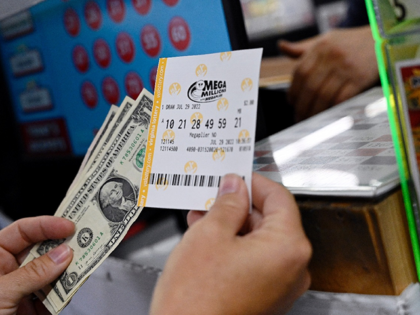 A person buys a Mega Millions lottery ticket at a store in Arlington, Virginia on July 29,
