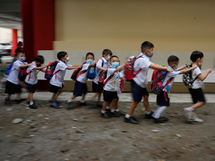 Students fall in line during the opening of classes at the San Juan Elementary School in Pasig, Philippines on Monday, Aug. 22, 2022. Millions of students wearing face masks streamed back to grade and high schools across the Philippines Monday in their first in-person classes after two years of coronavirus …