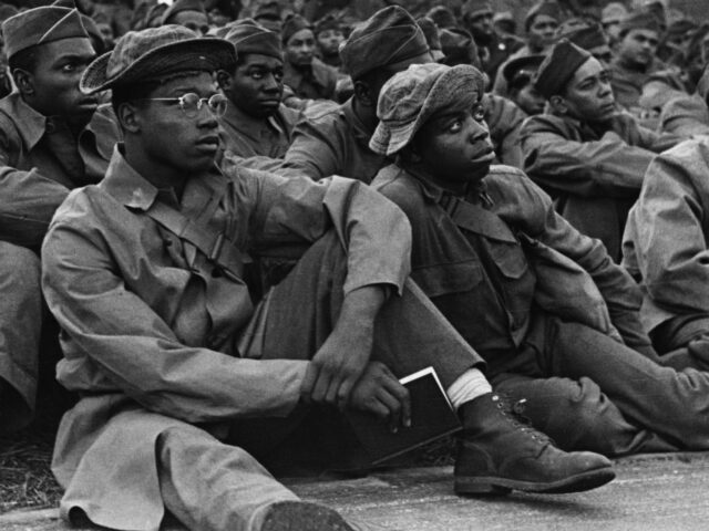 African American U.S. soldiers listen to a presentation at their posting in England midway