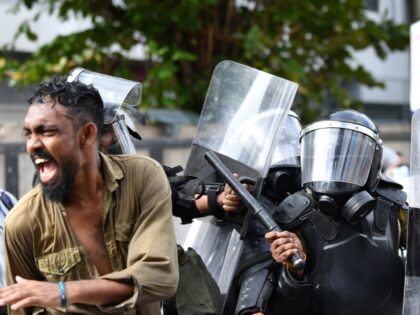 Sri Lankan police officers wearing riot gear detain a protester during the Inter Universit