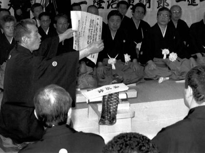 GANGLAND RITE - The new boss, left of a Tokyo area yakuza syndicate, reads aloud his pledge of allegiance to the "family," country and Amaterasu, the sun goddess, during a recent succession ceremony witnessed by some 70 underwold bosses during February/March 1991. The number of gangsters is estimatzed at around …