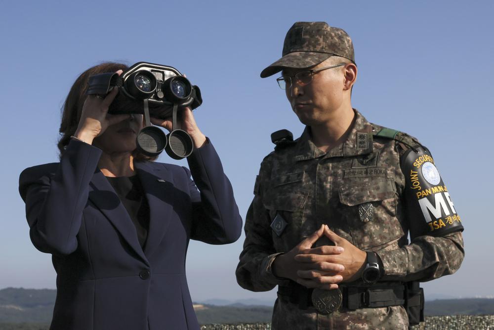 U.S. Vice President Kamala Harris, left, uses binoculars at the military observation post as she visits the demilitarized zone (DMZ) separating the two Koreas, in Panmunjom, South Korea Thursday, Sept. 29, 2022. (Leah Millis/Pool Photo via AP)