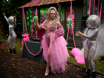 Daisy the Drag Queen Gardener dances next to performers wearing disco ball heads by the "The Green Room" show garden at the RHS (Royal Horticultural Society) Chelsea Flower Show in London, Monday, Sept. 20, 2021. World-renowned and quintessentially British, the annual show is a celebration of horticultural excellence and innovation. …