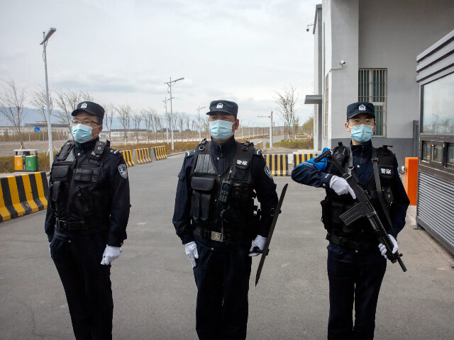 FILE - Police officers stand at the outer entrance of the Urumqi No. 3 Detention Center in