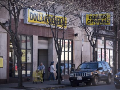A pedestrian pushes a cart outside a Dollar General Corp. store in Chicago, Illinois, U.S.