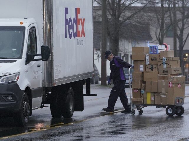 Holiday Shipping A driver with FedEx carries packages away from a van, Tuesday, Dec. 8, 20