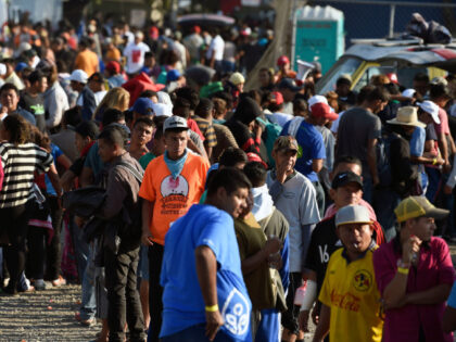 Central American migrants, taking part in a caravan heading to the US, queue to receive a meal at a temporary shelter in Irapuato, Guanajuato state, Mexico on November 11, 2018. - The trek from tropical Central America to the huge capital of Mexico is declining the health of the migrant …