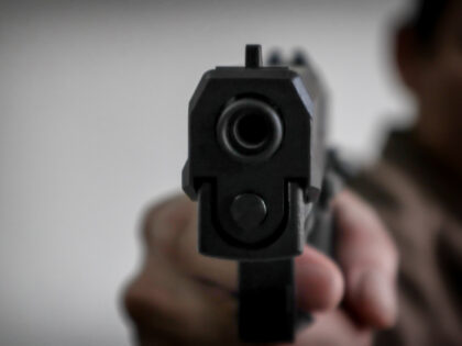 Gunman aiming his target.terrorism shoots a pistrol handgun.Criminal murder and violent concept - Film grain effect