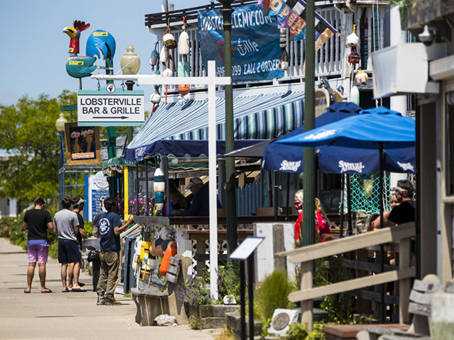People gather outside of restaurants on Martha's Vineyard in Oak Bluffs, Massachusetts, U.S., on Thursday, June 18, 2020. Governor Charlie Baker may make an announcement by the end of this week regarding a timeline for restaurants to be permitted to resume indoor table service with many restrictions in place regarding distancing, cleaning protocols, and other measures aimed at slowing the spread of Covid-19, Eater Boston reported. Photographer: Adam Glanzman/Bloomberg via Getty Images