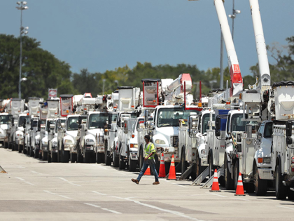 Dozens of utility trucks are lined up to be processed by Florida Power & Light at Daytona International Speedway on Saturday, August 1, 2020. Thousands of electric lineman crews and other employees were processed at the site to be sent to staging centers in preparation for Hurricane Isaias. (Stephen M. …
