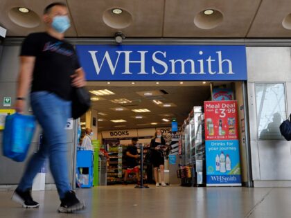 Pedestrians wearing a face mask or covering due to the COVID-19 pandemic, walk past a WH Smith store in London on August 5, 2020, following the announcement the retailer could cut 1500 jobs, and close up to 14 stores. - WH Smith said on Wednesday that it is planning to …