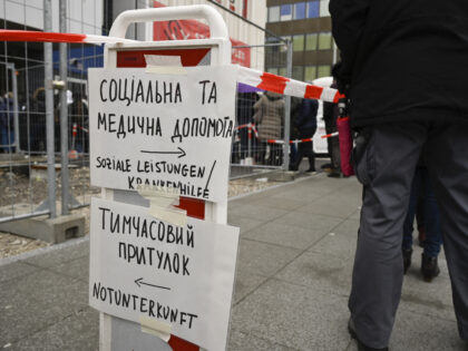 Refugees from Ukraine queue in front of the social welfare office near the main railway station as boards in German and Ukrainian read "benefits and health help" and "emergency accomodation" in Stuttgart, southern Germany, on March 15, 2022, where they can apply for benefits and health insurance certificates. (Photo by …