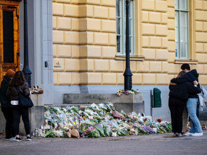 Mourners stand by flowers, candles and greetings placed on the stairs at a memorial makeshift outside Malmoe Latin School, in Malmo, southern Sweden on March 22, 2022, two days after two women in their 50s were killed at the secondary school. - The district court decided after a short hearing …