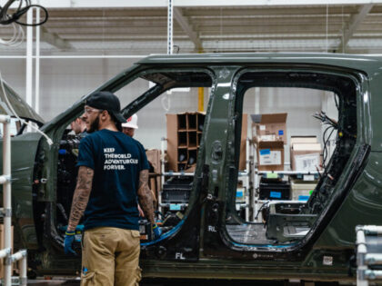 Workers assembly components of a Rivian R1T electric vehicle (EV) pickup truck at the company's manufacturing facility in Normal, Illinois, US., on Monday, April 11, 2022. Rivian Automotive Inc. produced 2,553 vehicles in the first quarter as the maker of plug-in trucks contended with a snarled supply chain and pandemic challenges. …