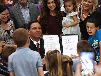 Florida Governor Ron DeSantis displays a tax relief law after signing it which will provid