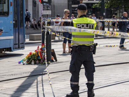 OSLO, NORWAY - JUNE 25: Police officers stand on patrol, as flowers and rainbow flags are placed along a street near a restaurant with windows shattered by the shooting near a gay club on June 25, 2022 in Oslo, Norway. Two people were killed and at least 10 were injured …