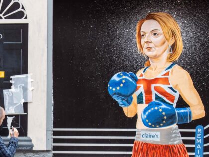 TOPSHOT - Artist Ciaran Gallagher puts the finishing touches to a new mural in Belfast city centre , depicting contenders to become the country's next Prime minister and leader of the Conservative party Britain's former Chancellor to the Exchequer Rishi Sunak (L) and British Foreign Secretary Liz Truss (R) dressed …