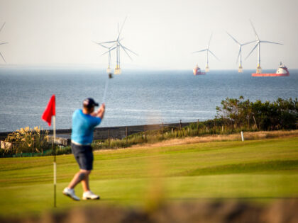 Golfers play at Nigg Bay Golf Club, overlooking the Port of Aberdeen and the Aberdeen Bay Wind Farm, operated by Vattenfall AB, in Aberdeen, UK, on Monday, July 18, 2022. Aberdeen in northeast Scotland is trying to make the leap from an oil town to a renewables hub amid growing …