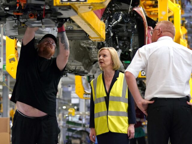 Contender to become the country's next Prime minister and leader of the Conservative party British Foreign Secretary Liz Truss (C) speaks with members of staff during a visit at the Jaguar Land Rover plant in Solihull, on August 23, 2022 as part of her political campaign. (Photo by Jacob King …