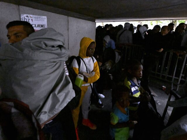 Asylum seekers wait outside the headquarters of the Fedasil Federal Agency For The Recepti