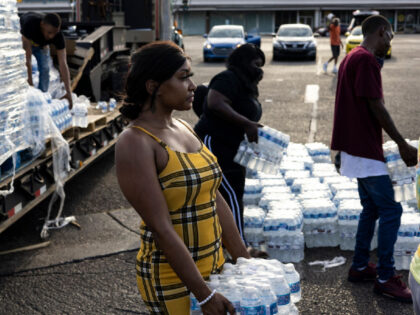 JACKSON, MS - AUGUST 31: Aelicia Hodge (C) helps hand out cases of bottled water at a Mississippi Rapid Response Coalition distribution site on August 31, 2022 in Jackson, Mississippi. Jackson is experiencing a third day without reliable water service after river flooding caused the main treatment facility to fail. …