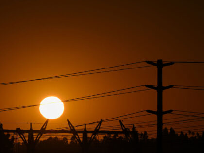 The sun sets behind electric power lines as the California Independent System Operator ann