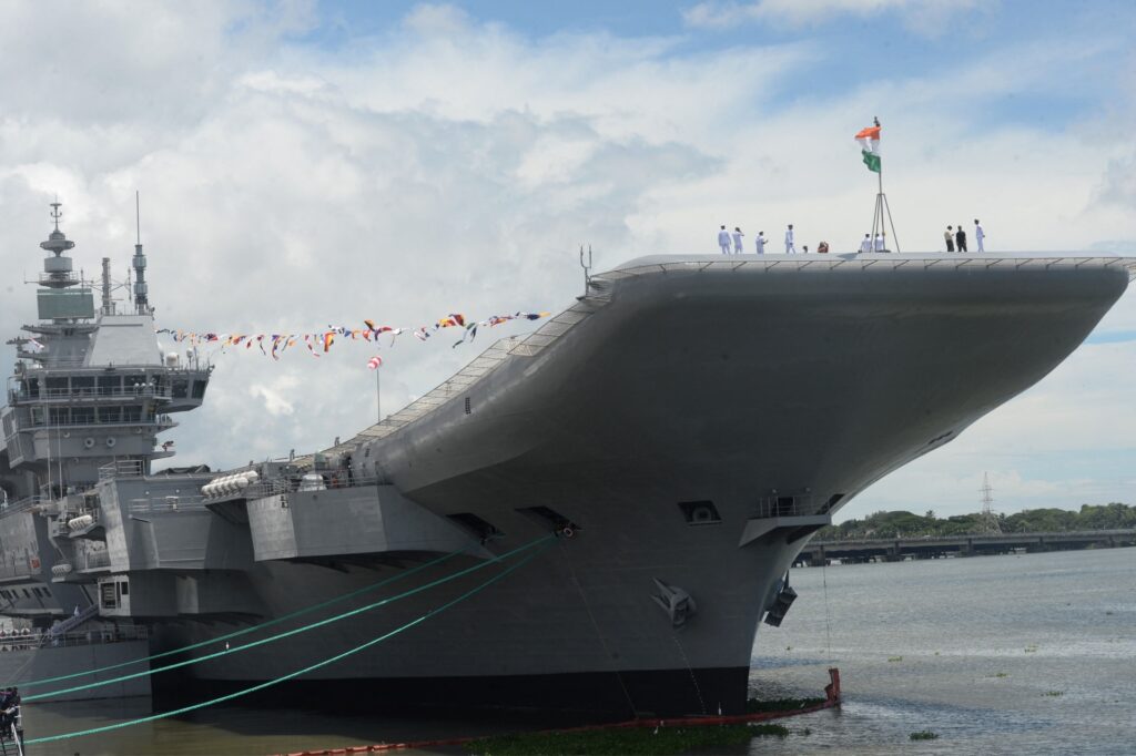 Indian Navy officers gather on the deck of the Indian indigenous aircraft carrier INS Vikrant during its commissioning at Cochin Shipyard in Kochi on September 2, 2022. - India debuted its first locally made aircraft carrier on September 2, a milestone in government efforts to reduce its dependence on foreign arms and counter China's growing military assertiveness in the region. (Photo by Arun SANKAR / AFP) (Photo by ARUN SANKAR/AFP via Getty Images)