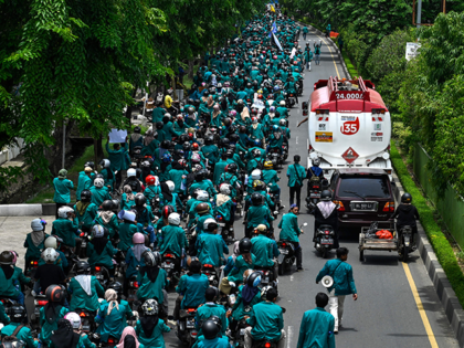 A fuel truck drives past university students marching along a road during a protest against the price of gasoline in Banda Aceh on September 6, 2022. (Photo by CHAIDEER MAHYUDDIN / AFP) (Photo by CHAIDEER MAHYUDDIN/AFP via Getty Images)