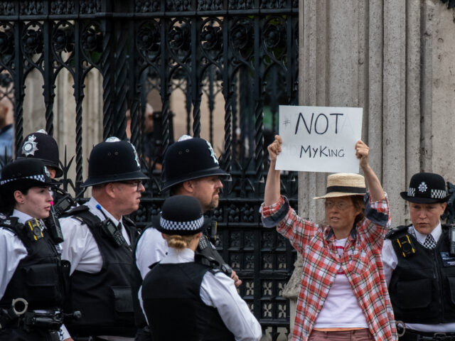 LONDON, ENGLAND - SEPTEMBER 12: An anti-monarchy protester is escorted by police outside t