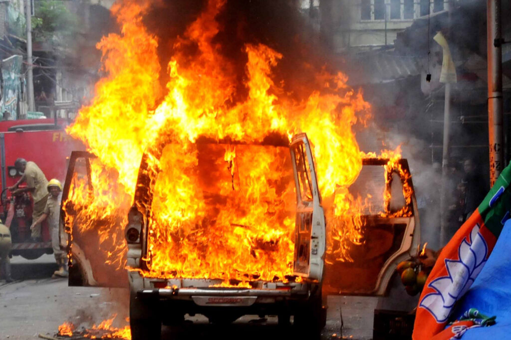 Firefighters attempt to extinguish the flames in an Indian police vehicle burning as protesters clash with police - Bharatiya Janata Party (BJP) activists marching towards the state secretariat during a protest against West Bengal's government in Kolkata on September 13, 2022. (Photo by Debajyoti Chakraborty/NurPhoto via Getty Images)