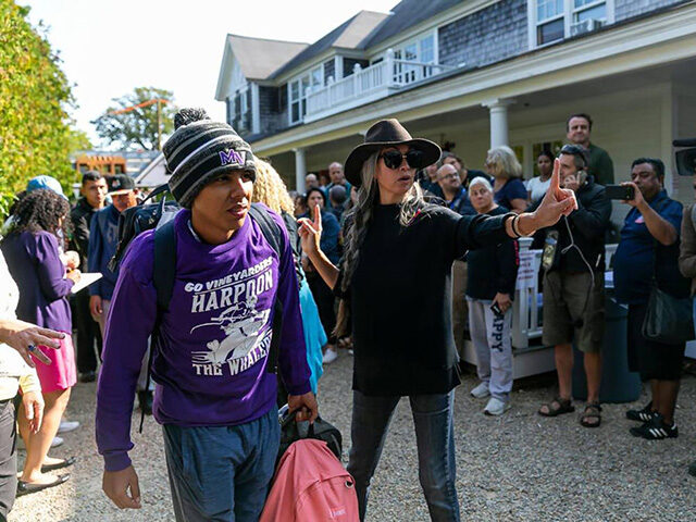 A Venezuelan migrant is led onto a bus at St. Andrews Episcopal Church on Friday, Sept. 16