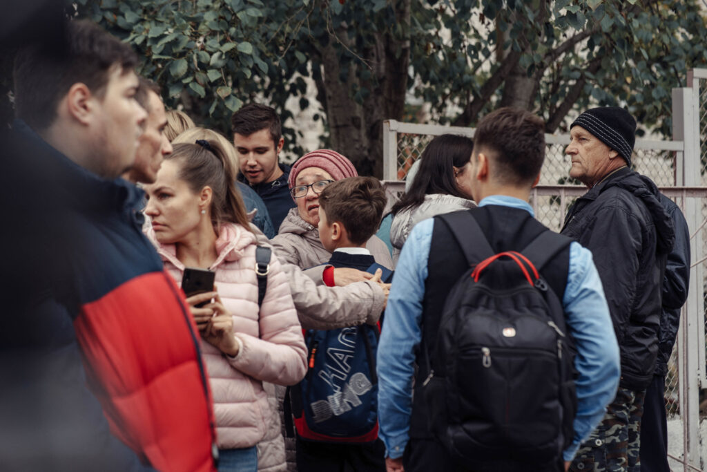 A woman hugs a boy surrounded by other people near the scene of a shooting in school No88 in Izhevsk on September 26, 2022. - The death toll has risen to 13 people, including seven children, after a man opened fire on September 26 at his former school in central Russia, authorities said. - Russia OUT (Photo by Maria BAKLANOVA / Kommersant Photo / AFP) / Russia OUT (Photo by MARIA BAKLANOVA/Kommersant Photo/AFP via Getty Images)