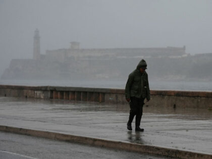 A man walks by the Malecon in Havana on September 27, 2022, during the passage of hurricane Ian. - Hurricane Ian made landfall in western Cuba early Tuesday, with the storm prompting mass evacuations and fears it will bring widespread destruction as it heads for the US state of Florida. …