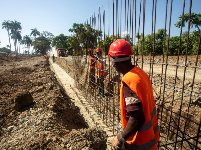 Workers build a border wall between Haiti and the Dominican Republic to stop the flow of m