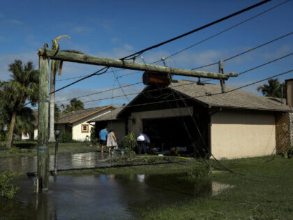 A broken utility pole on a flooded street following Hurricane Ian in Fort Myers, Florida,