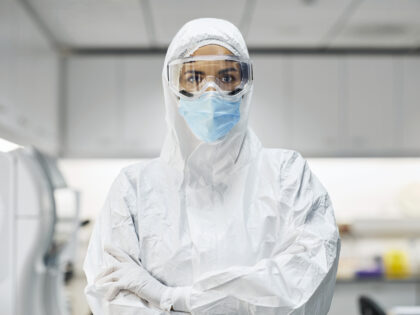 Portrait of female doctor wearing protective suit and face mask. Confident healthcare work