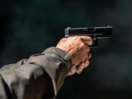 Cropped Hand Of Man Holding Gun - stock photo