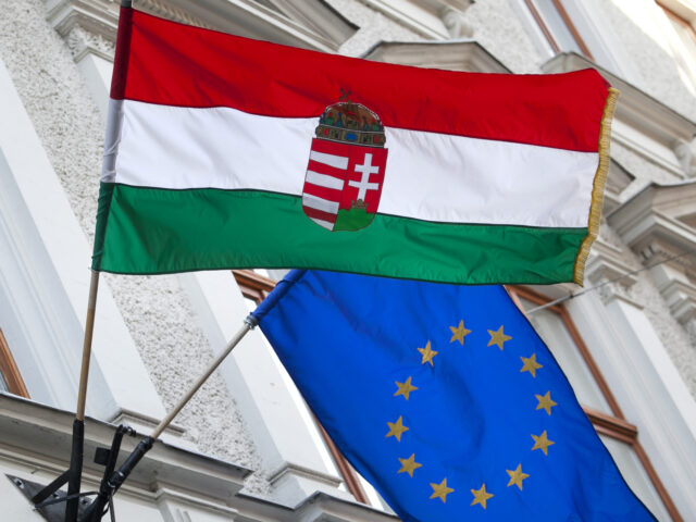 A Hungarian national flag, left, and a European Union flag fly outside a building in central Budapest, Hungary, on Wednesday, March 7, 2012. Hungary's industrial output unexpectedly fell in January as auto production plunged, raising concern about the economy's ability to avert a recession this year. Photographer: Balazs Mohai/Bloomberg via …