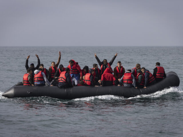 AT SEA, ENGLAND - AUGUST 04: An inflatable craft carrying migrants crosses the shipping la