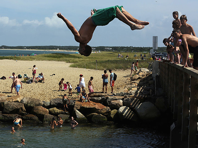 EDGARTOWN, MA - AUGUST 11: A boy jumps off 'Jaws Bridge' during JawsFest: The Tribute, a festival celebrating the film Jaws, on the island of Martha’s Vineyard on August 11, 2012 in Edgartown, Massachusetts. The film was primarily shot in Martha’s Vineyard and tells the story of a massive great white shark who attacks humans along the coast of the fictional Amity Island. In the film, the great white shark swims through this channel to kill a boater in a seaside pond. A man was confirmed to have been bitten by a great white shark less than two weeks ago along the shoreline of nearby Cape Cod. An increase in the seal population on Cape Cod has led to increased shark sightings including great whites. (Photo by Mario Tama/Getty Images)