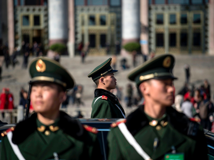 Paramilitary police officers stand in front of the Great Hall of the People during the ope