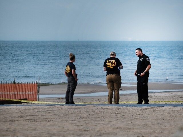 Police work along a stretch of beach at Coney Island which is now a crime scene after a mo