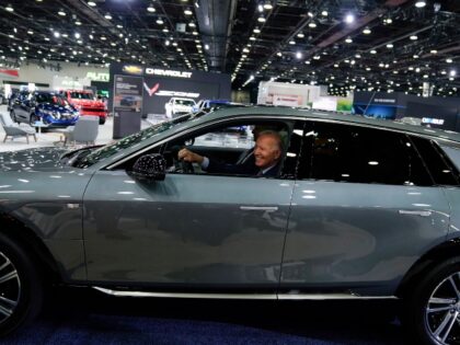 President Joe Biden drives a Cadillac Lyriq through the show room during a tour at the Detroit Auto Show, Wednesday, Sept. 14, 2022, in Detroit. (AP Photo/Evan Vucci)