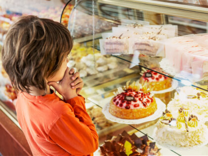 Boy looking at cakes - stock photo