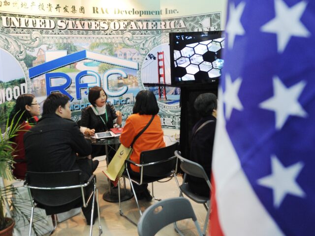 Potential Chinese real estate investors look at a display of United States property for sa
