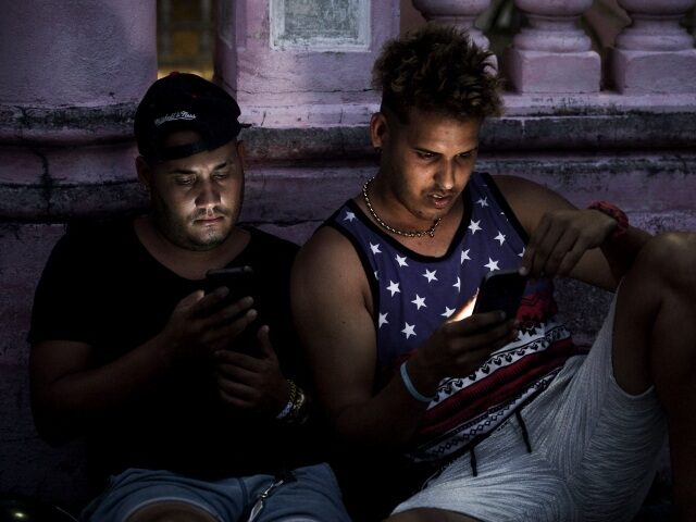 Young Cubans connect to internet from their mobile phone in Havana, on June 6, 2019. - Cub