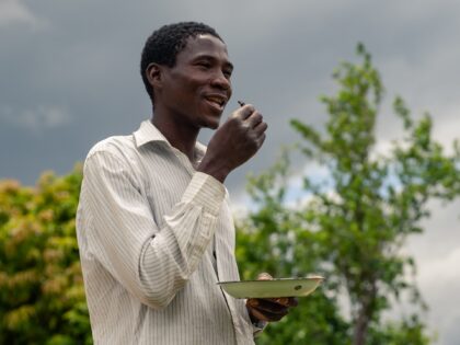 Earnmore Chikavaza eats from his plate of crunchy fried chafer beetles, also called Christmas beetles, which were fried after first boiling in a pot in Mhondoro, Zimbabwe, on December 16, 2020. - In Zimbabwean towns, food tastes have become westernised, but in the countryside, there remains a time-honoured tradition of …